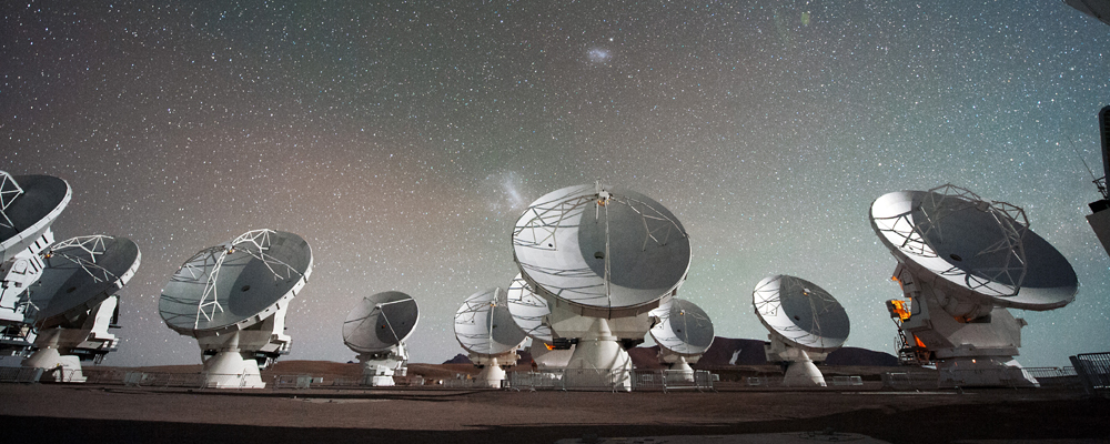 The Atacama Large Millimeter submillimeter Array (ALMA) by night under the Magellanic Clouds